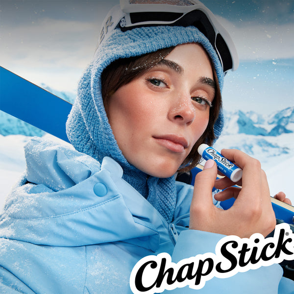 ChapStick Moisture+ SPF 15 lip balm on winter scene: person holding blue stick