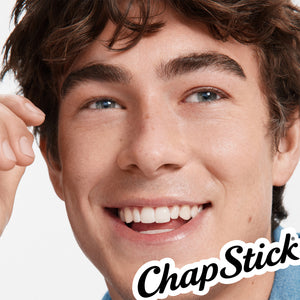 Person applying ChapStick classic medicated lip balm stick near smiling mouth