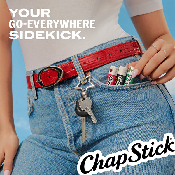 ChapStick lip balm tubes near jeans pocket with keys and hand visible