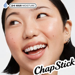 Red raspberry lip balm stick held near mouth on model lips