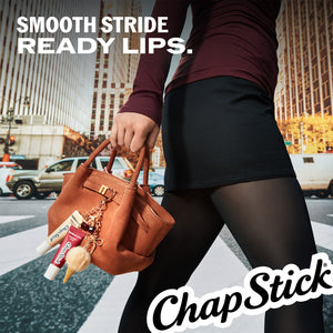 Lip balm tubes in hand, visible in brown bag